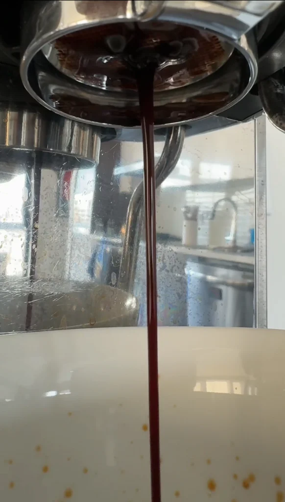 Espresso extraction with a bottomless portafilter in use.