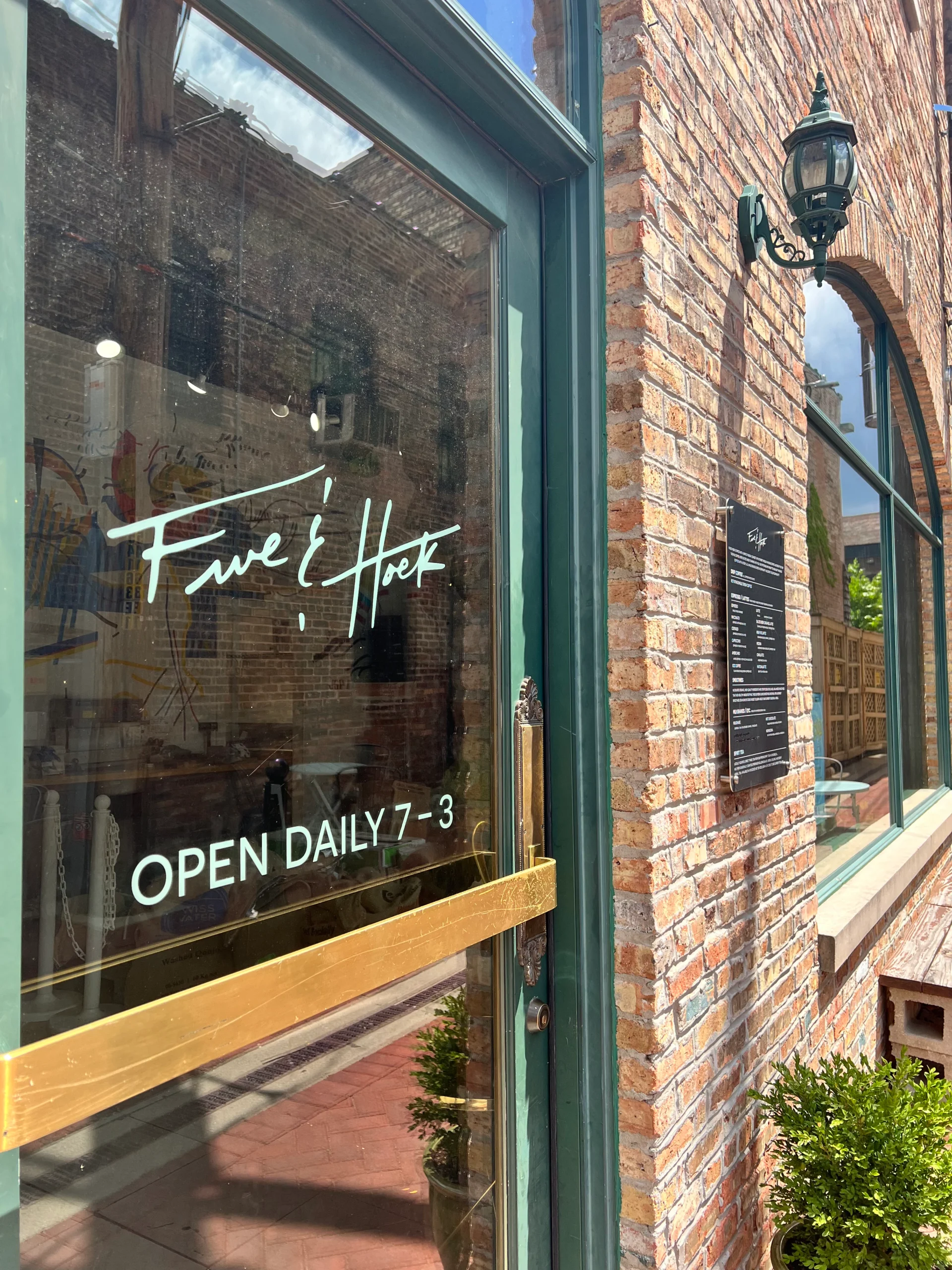 Five & Hoek Coffee logo displayed on the front glass door at their Wheaton, IL location, showing hours open 7 AM - 3 PM.